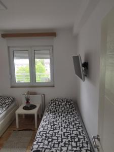 1 Schlafzimmer mit 2 Betten und einem TV an der Wand in der Unterkunft GRAND BB Apartman in Bajina Bašta