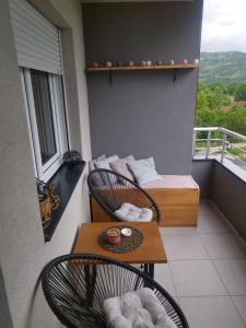 einen Balkon mit 2 Stühlen und einem Tisch in der Unterkunft GRAND BB Apartman in Bajina Bašta