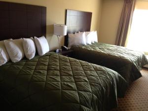 a hotel room with two beds and a window at Cobblestone Inn & Suites - Harper in Harper