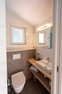 ein Bad mit einem WC und einem Waschbecken in der Unterkunft Mljet 4You - Beach House in Sobra