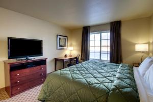 Habitación de hotel con cama y TV de pantalla plana. en Cobblestone Inn & Suites - Harper, en Harper
