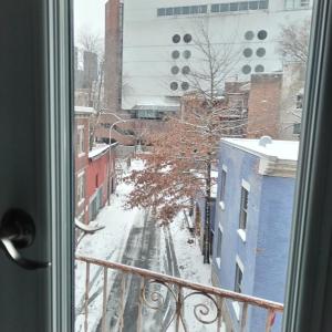 een raam met uitzicht op een met sneeuw bedekte straat bij La maisonnette in Montreal