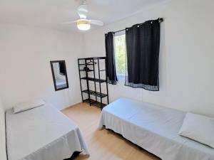 a room with two beds and a window at Apê no Centro de Madureira in Rio de Janeiro