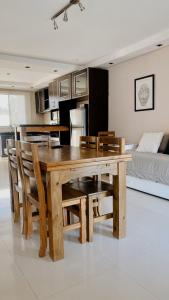 una mesa de comedor de madera y sillas en la sala de estar en TERRAZAS DE QUEQUEN en Quequén