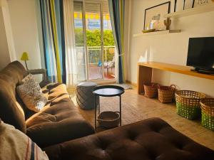 sala de estar con sofá marrón y TV en Apartamento 100m2 con piscina y jardín para 6 personas en Cambrils, en Cambrils