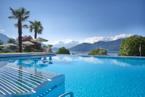 a swimming pool with a view of the mountains at Hotel Alexander in Weggis