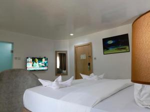 1 dormitorio con 2 camas blancas y TV de pantalla plana en Kakanfo Inn & Conference Centre, en Ibadán 18 fotos más