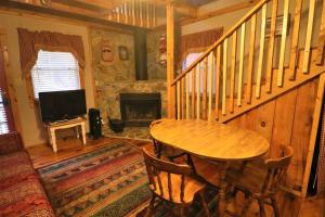 uma sala de estar com uma mesa e uma lareira em Mountain Cabin in woods 3 minutes to Helen #13 em Helen