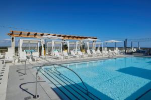 a swimming pool with lounge chairs and a swimming poolvisor at Hotel Effie Sandestin Resort, Autograph Collection in Destin