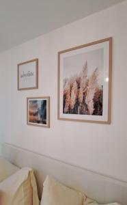 two framed photographs on a white wall above a couch at Soul Apart Suite in Munich