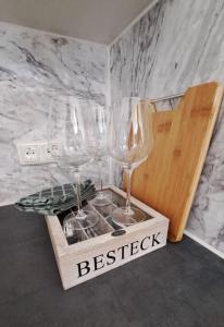 three wine glasses in a wooden box on a counter at Soul Apart Suite in Munich
