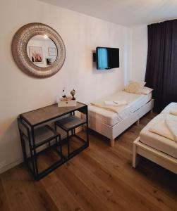 Pokój z 2 łóżkami i stołem z lustrem w obiekcie Soul Apart Suite w Monachium