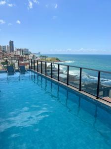una piscina con vistas al océano en LINDO FLAT NO FAROL DA BARRA, en Salvador