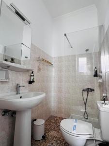 een witte badkamer met een wastafel en een toilet bij Blue Sardines in Pythagoreio