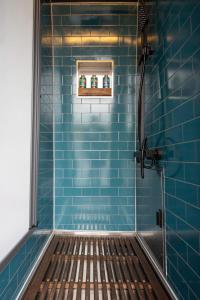 a blue tiled shower with a bench in it at Trippie Campers in Uphall