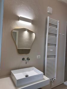 Un baño con un lavabo blanco y un espejo. en MAISON BENGASI, en Civitanova Marche