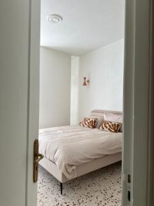 Un dormitorio con una cama en una habitación blanca. en MAISON BENGASI, en Civitanova Marche