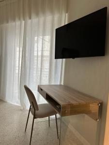 a desk with a chair and a television on a wall at MAISON BENGASI in Civitanova Marche