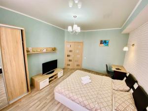 een kleine kamer met een bed en een televisie bij Voyage 2 ROOMS Apartment in Chişinău