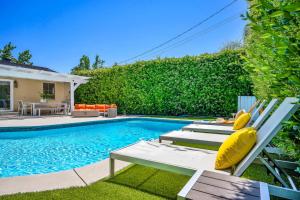 a swimming pool with two chairs next to a house at Sophia's Pool Oasis in Los Angeles +37 photos