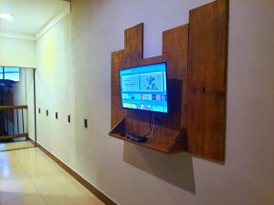TV de pantalla plana en la pared de una habitación en Suítes Capitólio Canastra en Capitólio