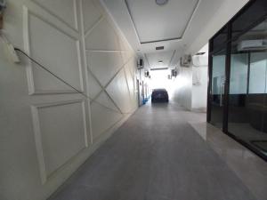 un corridoio vuoto con un'auto parcheggiata in un garage di OYO 93962 Jm Guest House a Pundong