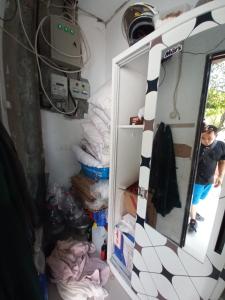 OYO 93962 Jm Guest House في Pundong: صبي واقف في غرفة مع مرآة