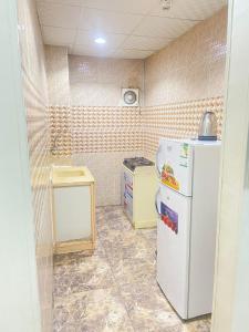 a small kitchen with a white refrigerator in a room at اجنحة التميز للوحدات السكنية in Medina