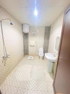 a bathroom with a toilet and a sink at اجنحة التميز للوحدات السكنية in Medina