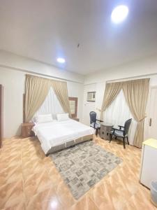 a bedroom with a bed and a desk and chairs at اجنحة التميز للوحدات السكنية in Medina