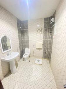 a bathroom with a toilet and a sink and a shower at اجنحة التميز للوحدات السكنية in Medina