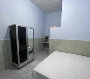 Un pat sau paturi într-o cameră la SPOT ON 93965 Ibrahim Guest House Syariah