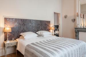 a bedroom with a large bed with a gray headboard at La Maison du Champlain - Chambres d'hôtes in Lille