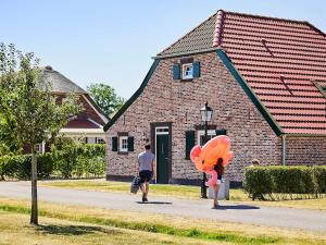 RoggelにあるNice farmhouse villa with PlayStation, in Limburgの二人の建物前の通りを歩く