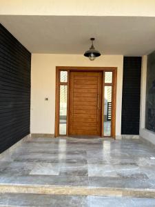 a front door of a house with a wooden door at Elkarma 4 in Sheikh Zayed