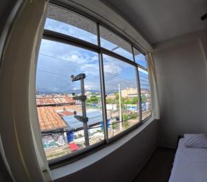 um quarto com uma janela com vista para a cidade em Hospedaje Koral em Tarapoto