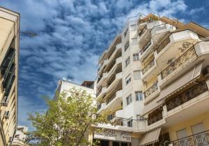 a tall white building with a blue sky in the background at Fabulous central apartment close to the sea! in Chalkida