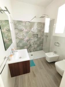 La salle de bains est pourvue d'un lavabo, de toilettes et d'une douche. dans l'établissement L'Angolo di Mimma, à Porto Cesareo
