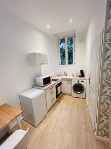 a small kitchen with a stove and a dishwasher at La Petite Rhonelle - Studio en hypercentre in Valenciennes