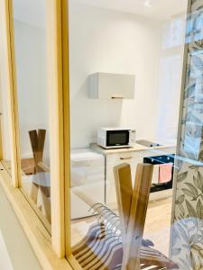 a view of a kitchen through a glass window at La Petite Rhonelle - Studio en hypercentre in Valenciennes +19 photos