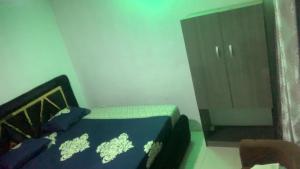 a small bedroom with a bed and a dresser at CLASSIC SUITES ANNEX in Ilorin