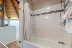 a bathroom with a tub and a shower with white tiles at The Octagon on the Beach in Seaside