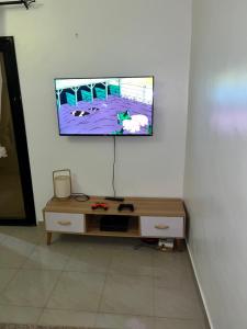 a tv hanging on a wall above a desk at Keur GORA, Sacré cœur 2 in Dakar