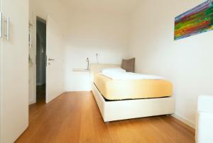 a bedroom with a bed in a white room at Ba mir Apartment in Appiano sulla Strada del Vino