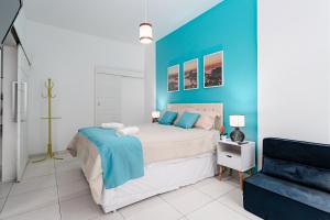 1 dormitorio con 1 cama grande y pared azul en Modern Copacabana Apartment, en Río de Janeiro