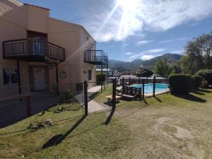a house with a yard with a swimming pool at Cabañas La Soleada in Potrero de los Funes