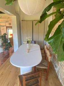 een witte tafel en stoelen in een kamer met planten bij Doniños74 in Ferrol
