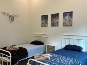 a bedroom with two beds and paintings on the wall at Thunder Hollow in Ruidoso