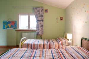a bedroom with two beds and a window at La Gipsofila Attic in Osimo