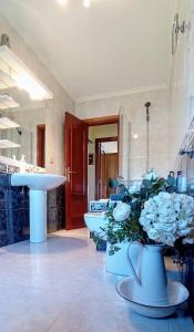 baño con lavabo y jarrón de flores en Apartamento en las afueras en Ribadeo